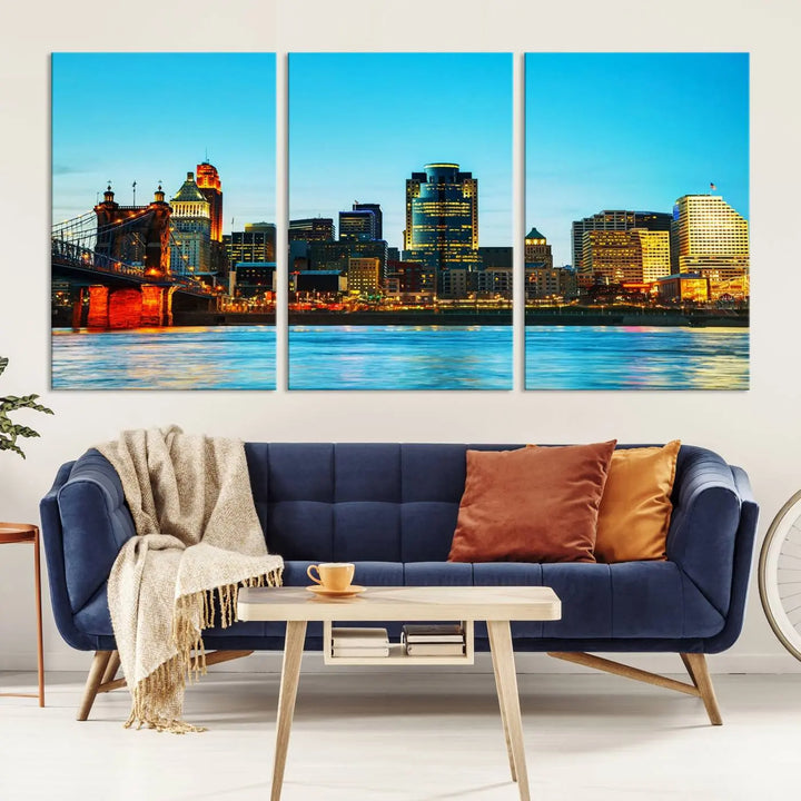 The "Cincinnati City Lights Bright Blue Skyline Cityscape View Wall Art Canvas Print" is displayed as a three-panel masterpiece. Expertly crafted on museum-quality polycotton canvas with a UV-protective coating, this artwork captures the essence of the city at dusk.