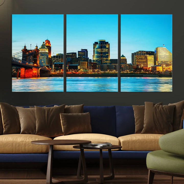 The "Cincinnati City Lights Bright Blue Skyline Cityscape View Wall Art Canvas Print" is displayed as a three-panel masterpiece. Expertly crafted on museum-quality polycotton canvas with a UV-protective coating, this artwork captures the essence of the city at dusk.