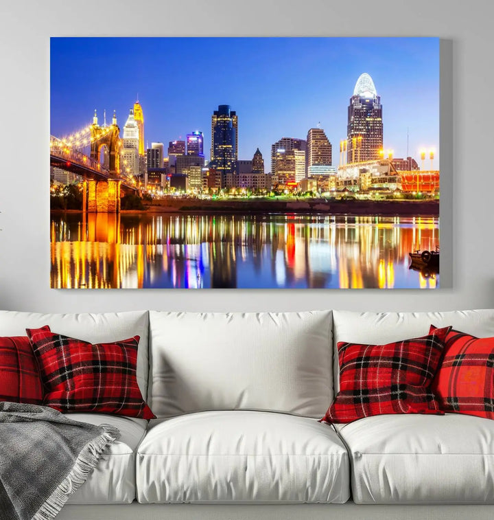 The "Cincinnati City Lights Night Skyline Cityscape View Wall Art Canvas Print" is a gallery-wrapped, museum-quality canvas illustrating a lit-up bridge and skyline at night. Enhanced with a UV-protective coating, this piece ensures lasting vibrancy.