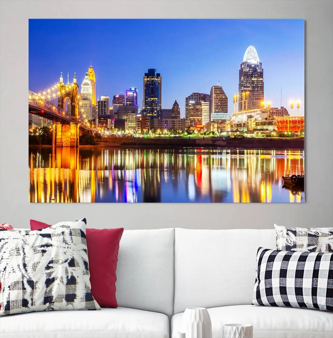 The "Cincinnati City Lights Night Skyline Cityscape View Wall Art Canvas Print" is a gallery-wrapped, museum-quality canvas illustrating a lit-up bridge and skyline at night. Enhanced with a UV-protective coating, this piece ensures lasting vibrancy.