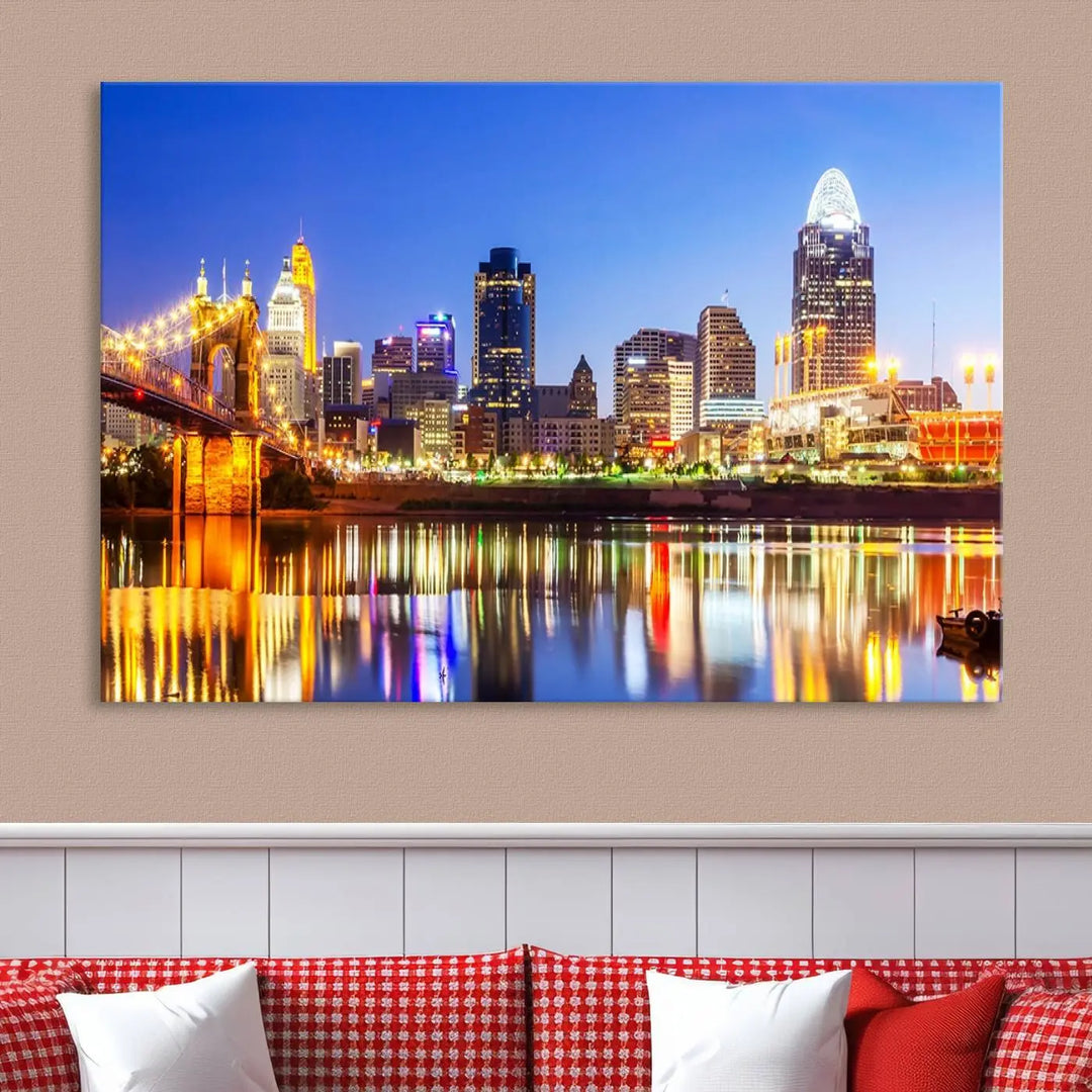 The "Cincinnati City Lights Night Skyline Cityscape View Wall Art Canvas Print" is a gallery-wrapped, museum-quality canvas illustrating a lit-up bridge and skyline at night. Enhanced with a UV-protective coating, this piece ensures lasting vibrancy.