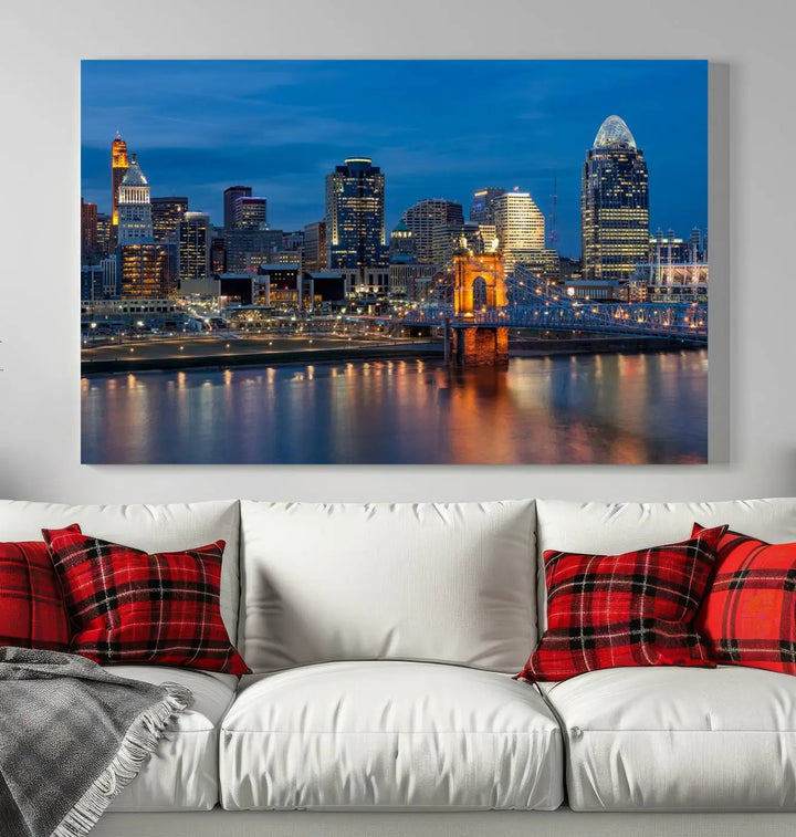 A triptych of the Cincinnati city lights night skyline, printed on museum-quality canvas with a UV-protective coating, hangs prominently on the wall.