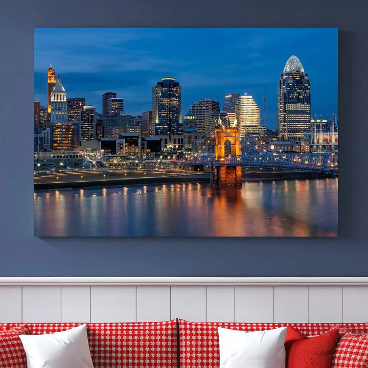 A triptych of the Cincinnati city lights night skyline, printed on museum-quality canvas with a UV-protective coating, hangs prominently on the wall.