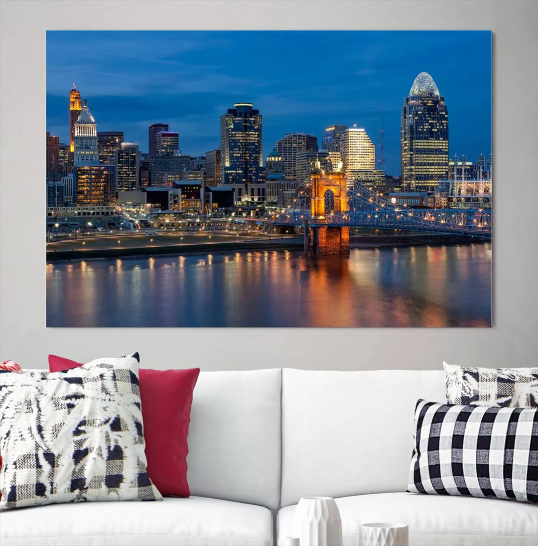 A triptych of the Cincinnati city lights night skyline, printed on museum-quality canvas with a UV-protective coating, hangs prominently on the wall.