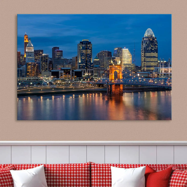 A triptych of the Cincinnati city lights night skyline, printed on museum-quality canvas with a UV-protective coating, hangs prominently on the wall.