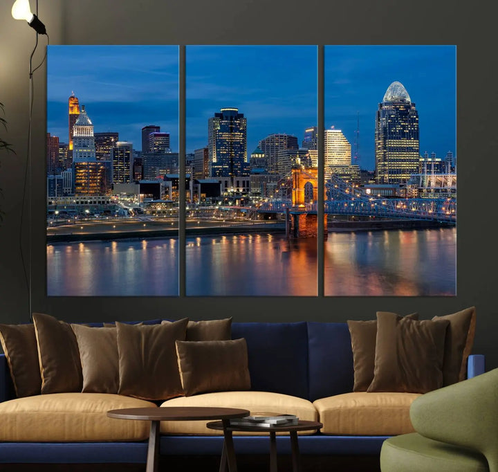 A triptych of the Cincinnati city lights night skyline, printed on museum-quality canvas with a UV-protective coating, hangs prominently on the wall.