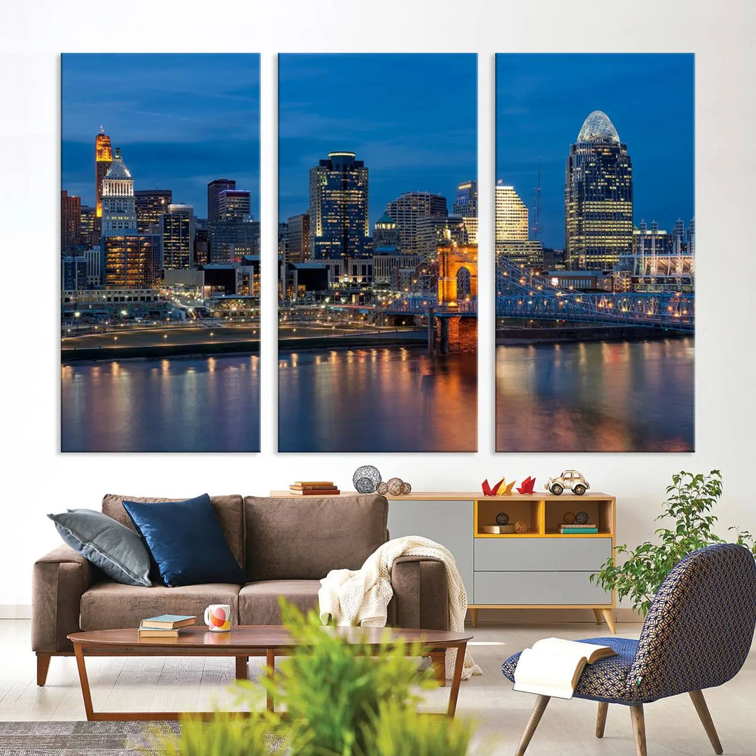 A triptych of the Cincinnati city lights night skyline, printed on museum-quality canvas with a UV-protective coating, hangs prominently on the wall.