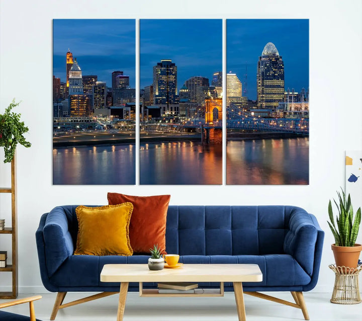 A triptych of the Cincinnati city lights night skyline, printed on museum-quality canvas with a UV-protective coating, hangs prominently on the wall.