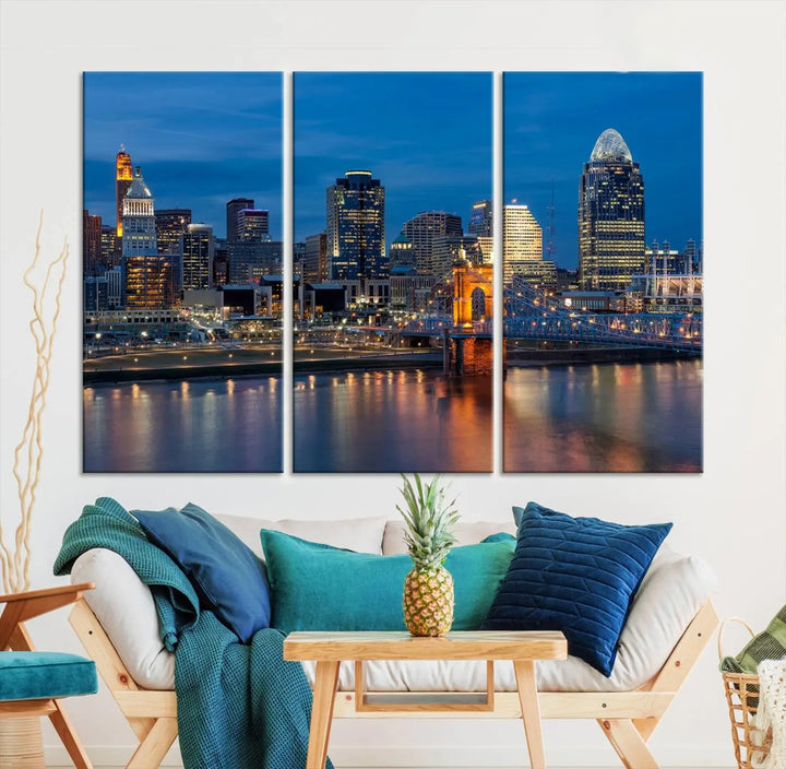 A triptych of the Cincinnati city lights night skyline, printed on museum-quality canvas with a UV-protective coating, hangs prominently on the wall.