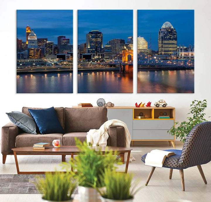 A triptych of the Cincinnati city lights night skyline, printed on museum-quality canvas with a UV-protective coating, hangs prominently on the wall.