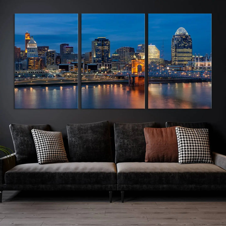 A triptych of the Cincinnati city lights night skyline, printed on museum-quality canvas with a UV-protective coating, hangs prominently on the wall.