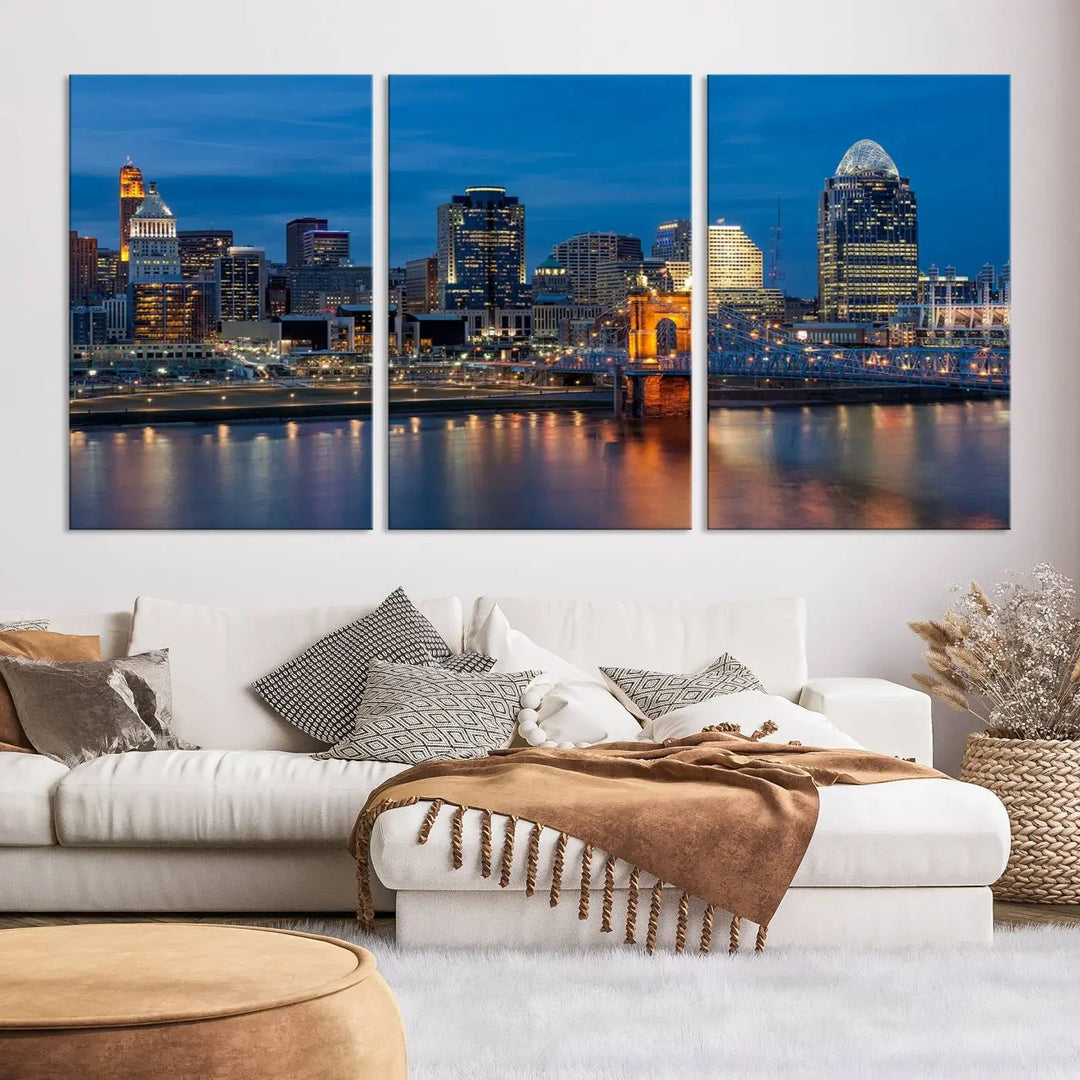 A triptych of the Cincinnati city lights night skyline, printed on museum-quality canvas with a UV-protective coating, hangs prominently on the wall.