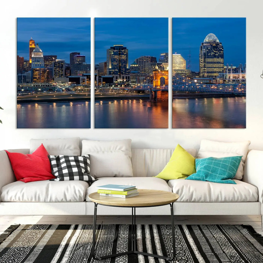 A triptych of the Cincinnati city lights night skyline, printed on museum-quality canvas with a UV-protective coating, hangs prominently on the wall.