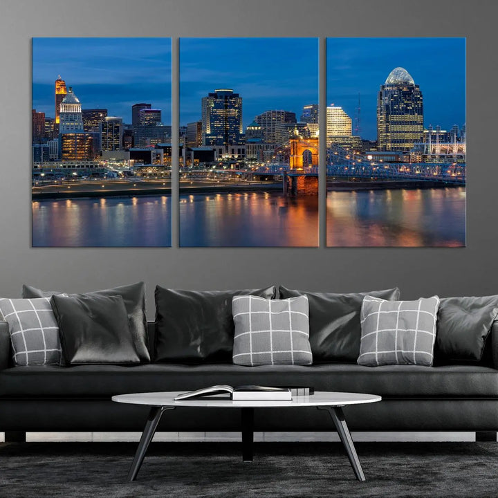 A triptych of the Cincinnati city lights night skyline, printed on museum-quality canvas with a UV-protective coating, hangs prominently on the wall.