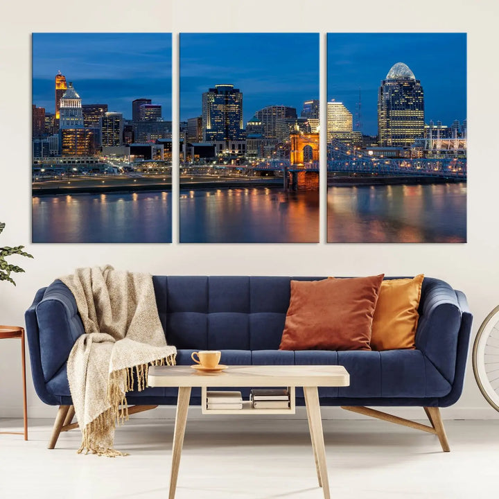 A triptych of the Cincinnati city lights night skyline, printed on museum-quality canvas with a UV-protective coating, hangs prominently on the wall.