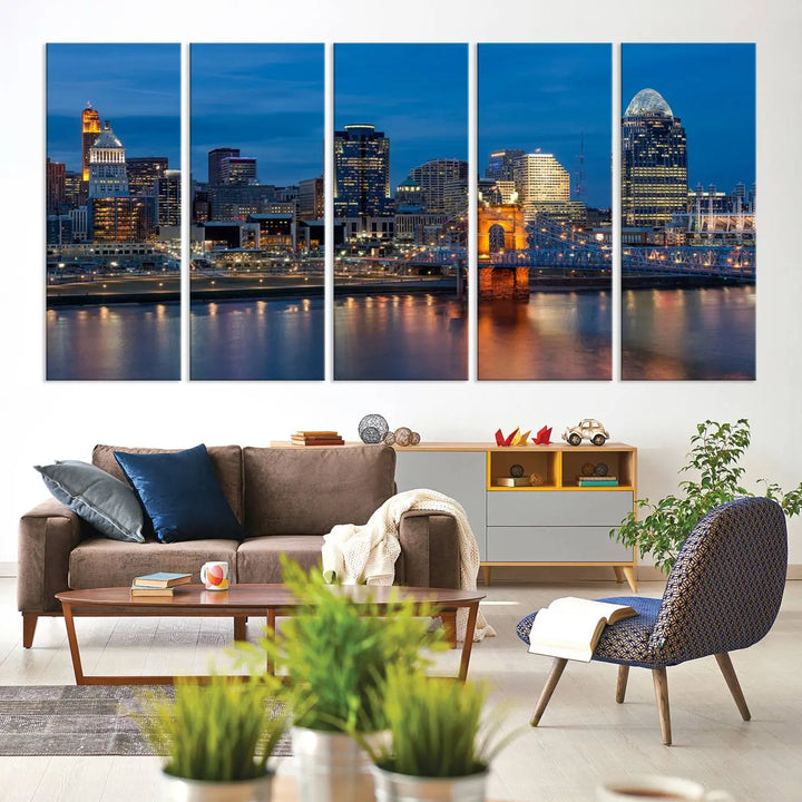 A triptych of the Cincinnati city lights night skyline, printed on museum-quality canvas with a UV-protective coating, hangs prominently on the wall.