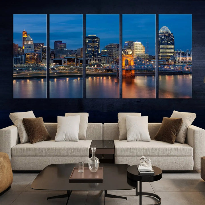 A triptych of the Cincinnati city lights night skyline, printed on museum-quality canvas with a UV-protective coating, hangs prominently on the wall.