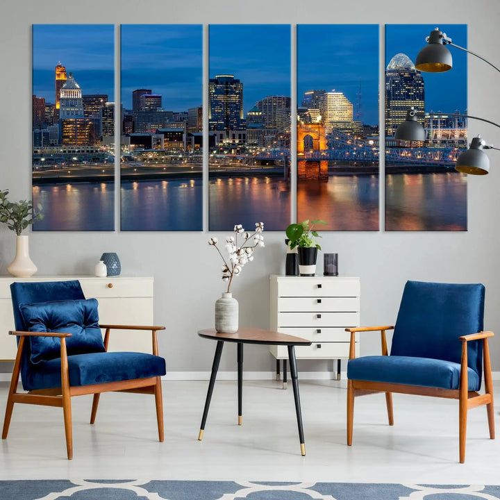 A triptych of the Cincinnati city lights night skyline, printed on museum-quality canvas with a UV-protective coating, hangs prominently on the wall.