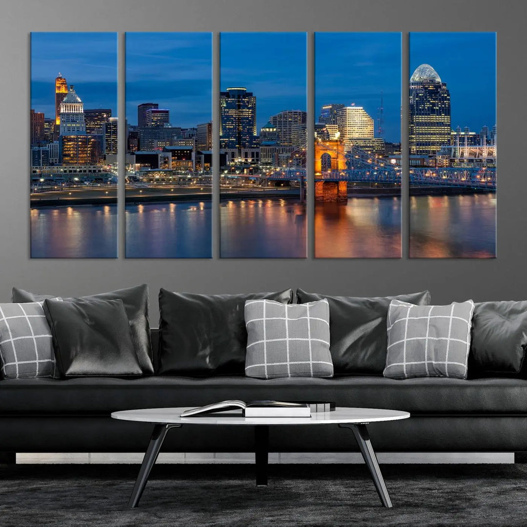 A triptych of the Cincinnati city lights night skyline, printed on museum-quality canvas with a UV-protective coating, hangs prominently on the wall.