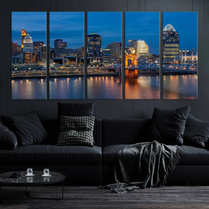 A triptych of the Cincinnati city lights night skyline, printed on museum-quality canvas with a UV-protective coating, hangs prominently on the wall.