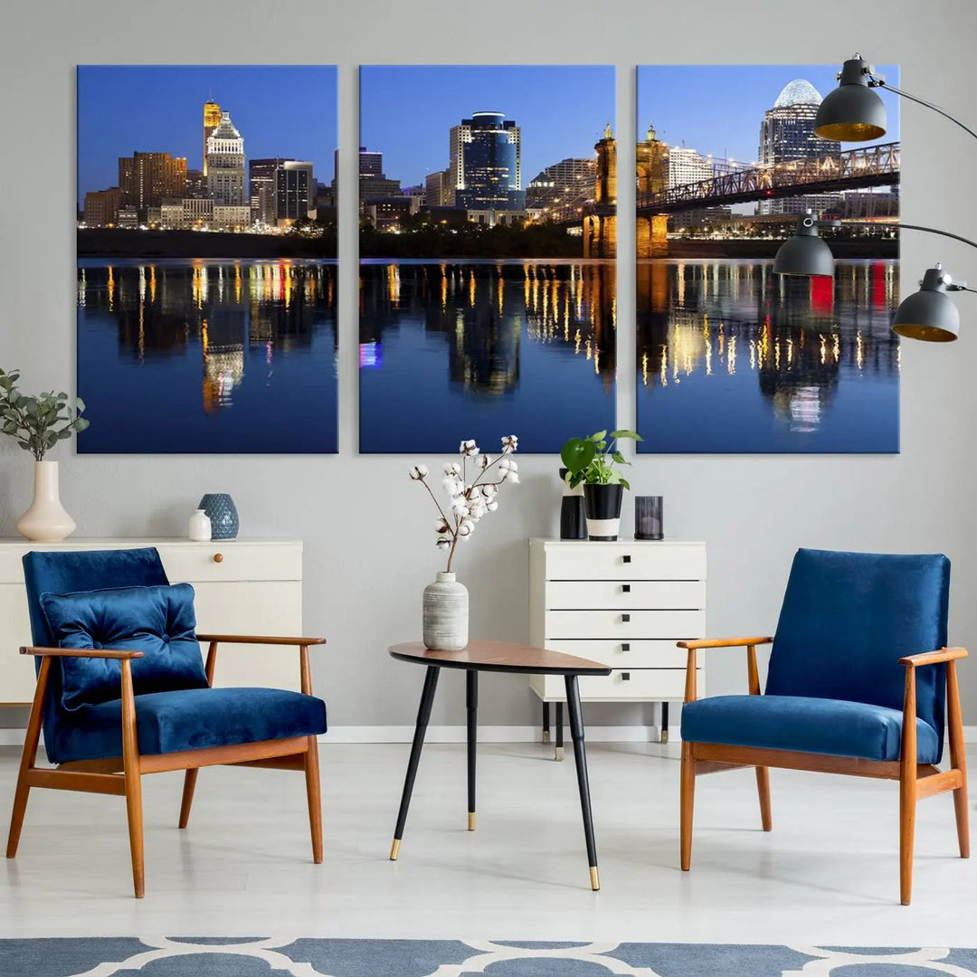 The Cincinnati City Lights Night Skyline Cityscape View Wall Art Canvas Print showcases a cityscape at night reflecting on water. It is crafted on museum-quality canvases with a UV-protective coating.