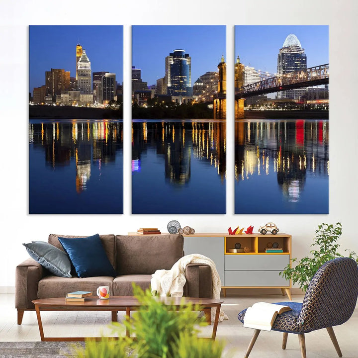 The Cincinnati City Lights Night Skyline Cityscape View Wall Art Canvas Print showcases a cityscape at night reflecting on water. It is crafted on museum-quality canvases with a UV-protective coating.