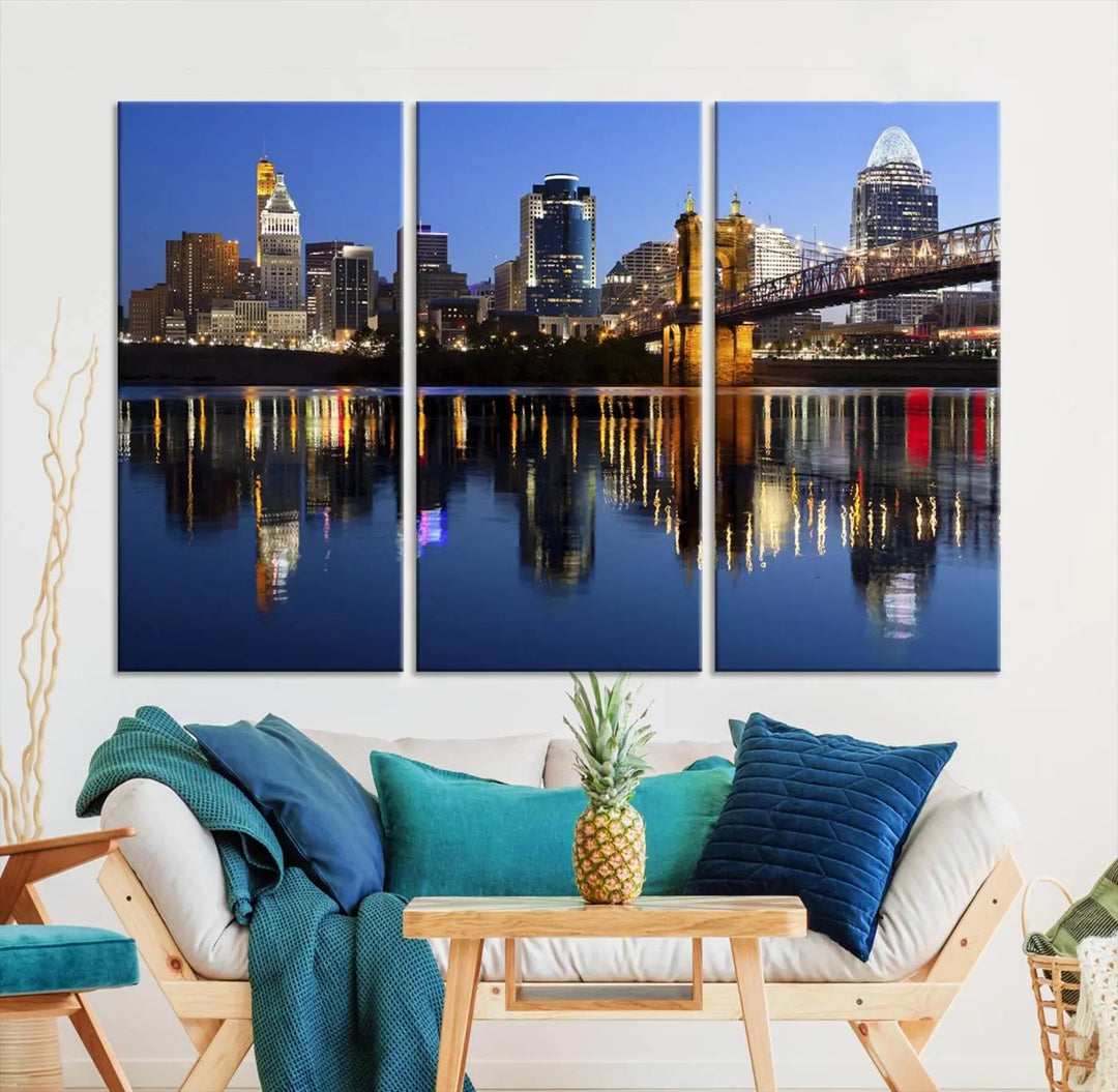 The Cincinnati City Lights Night Skyline Cityscape View Wall Art Canvas Print showcases a cityscape at night reflecting on water. It is crafted on museum-quality canvases with a UV-protective coating.