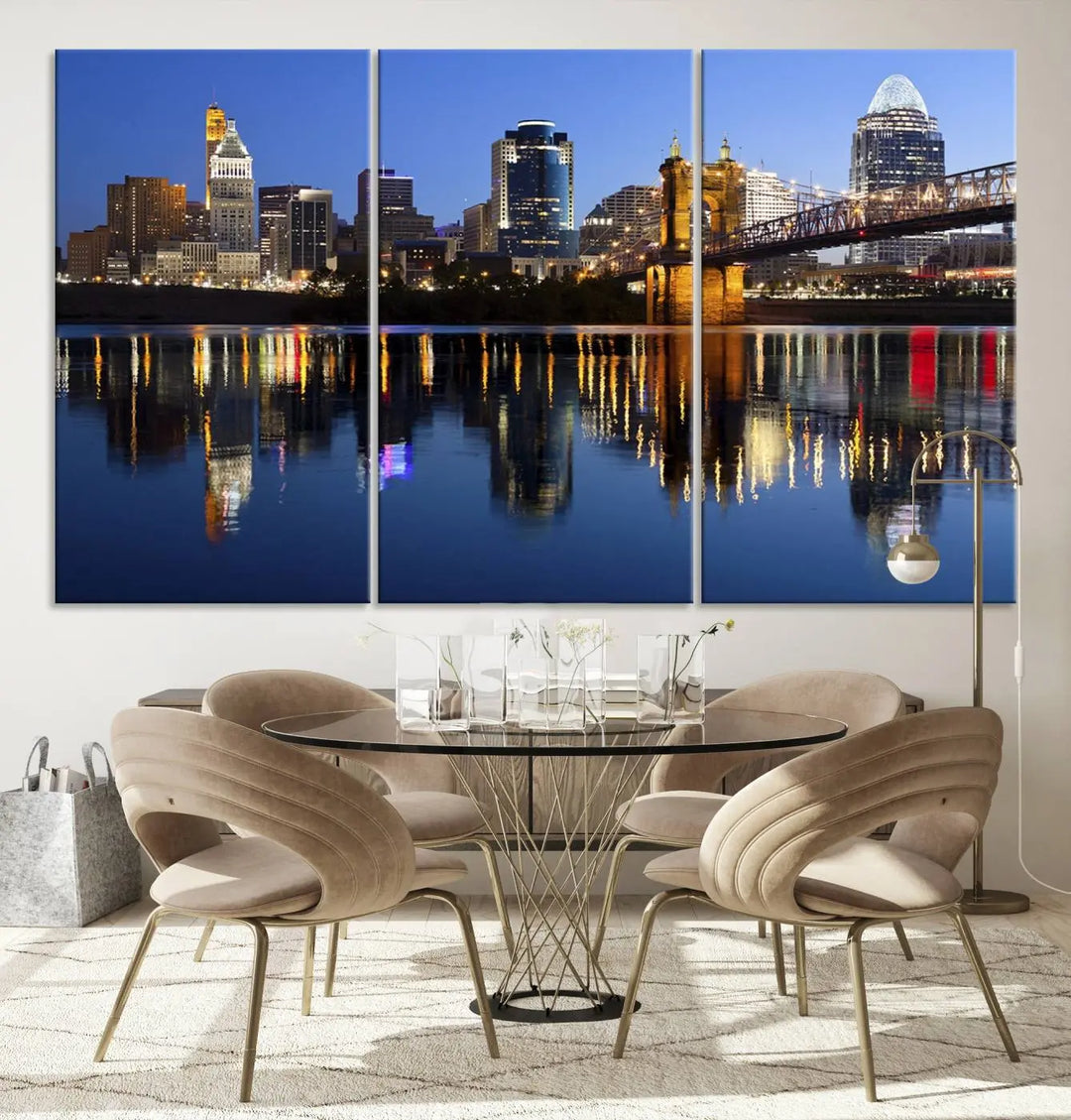 The Cincinnati City Lights Night Skyline Cityscape View Wall Art Canvas Print showcases a cityscape at night reflecting on water. It is crafted on museum-quality canvases with a UV-protective coating.