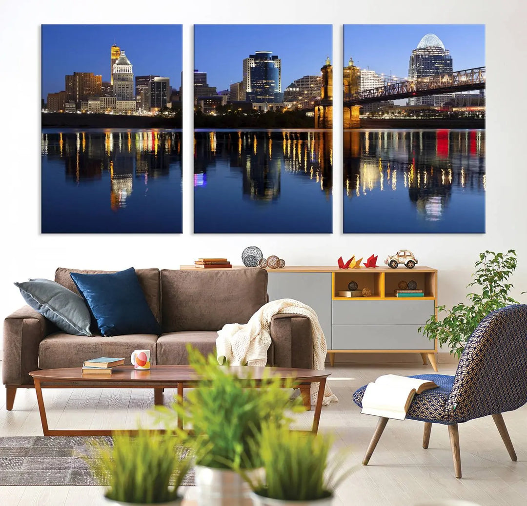 The Cincinnati City Lights Night Skyline Cityscape View Wall Art Canvas Print showcases a cityscape at night reflecting on water. It is crafted on museum-quality canvases with a UV-protective coating.