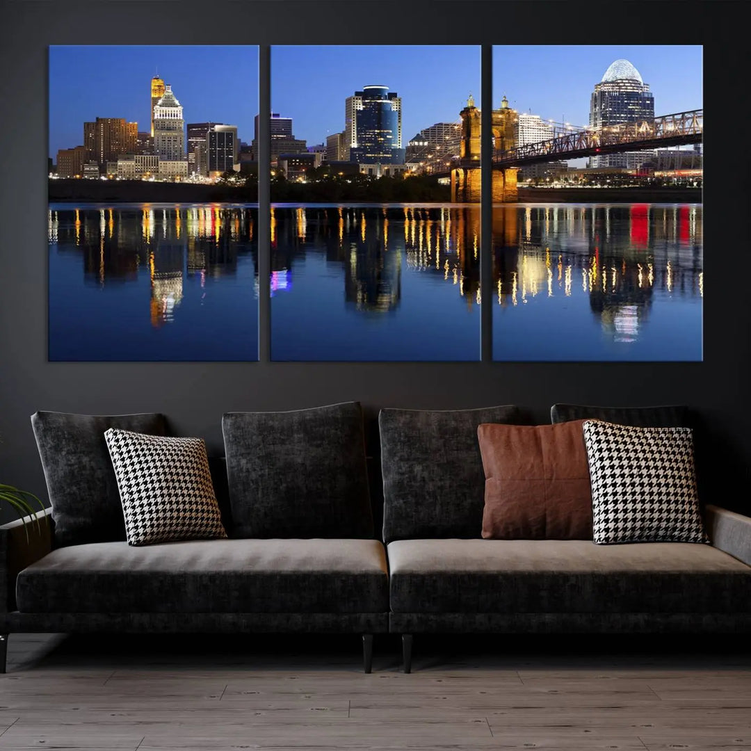 The Cincinnati City Lights Night Skyline Cityscape View Wall Art Canvas Print showcases a cityscape at night reflecting on water. It is crafted on museum-quality canvases with a UV-protective coating.