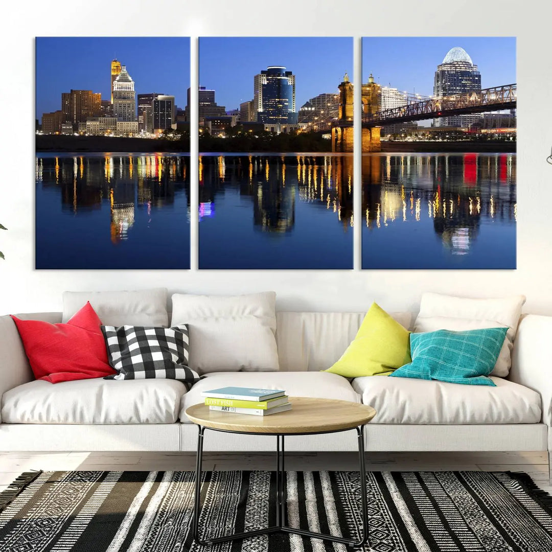 The Cincinnati City Lights Night Skyline Cityscape View Wall Art Canvas Print showcases a cityscape at night reflecting on water. It is crafted on museum-quality canvases with a UV-protective coating.