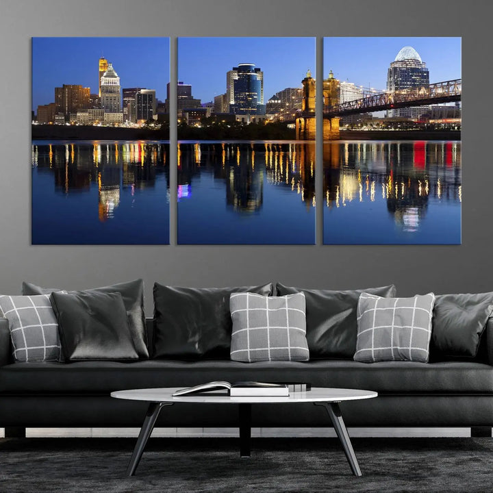 The Cincinnati City Lights Night Skyline Cityscape View Wall Art Canvas Print showcases a cityscape at night reflecting on water. It is crafted on museum-quality canvases with a UV-protective coating.