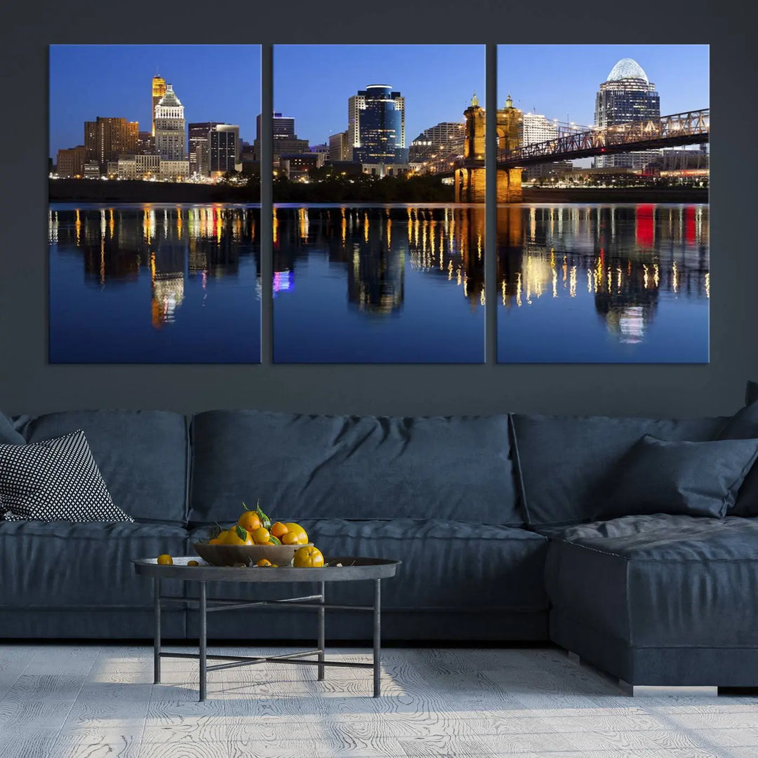 The Cincinnati City Lights Night Skyline Cityscape View Wall Art Canvas Print showcases a cityscape at night reflecting on water. It is crafted on museum-quality canvases with a UV-protective coating.