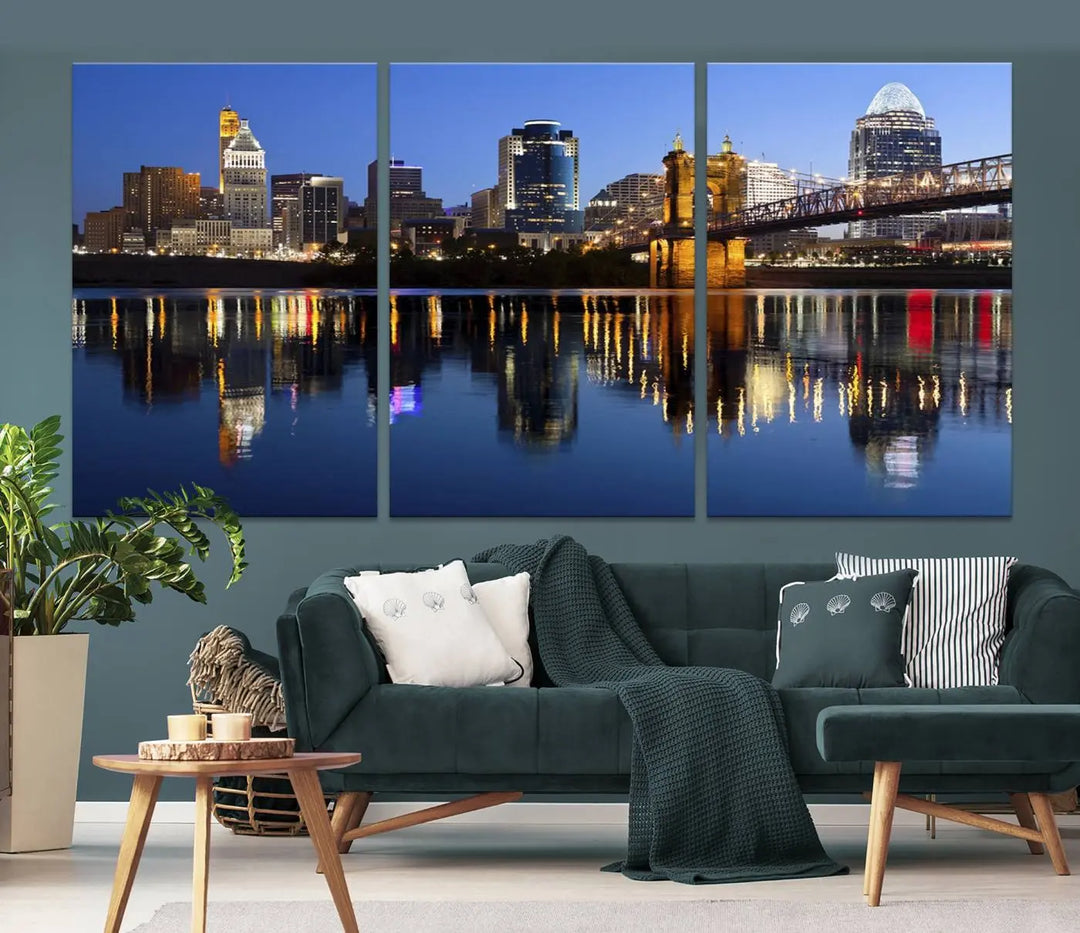 The Cincinnati City Lights Night Skyline Cityscape View Wall Art Canvas Print showcases a cityscape at night reflecting on water. It is crafted on museum-quality canvases with a UV-protective coating.