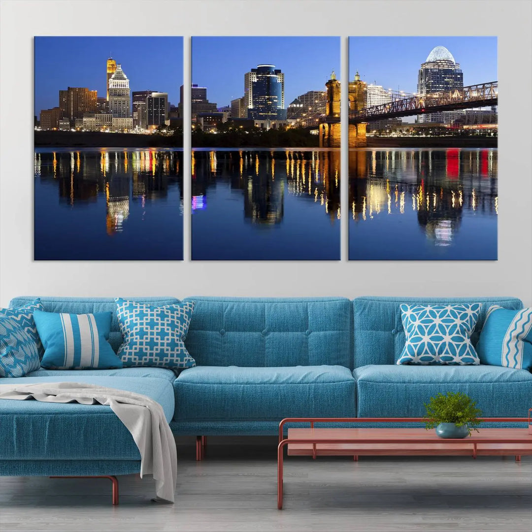 The Cincinnati City Lights Night Skyline Cityscape View Wall Art Canvas Print showcases a cityscape at night reflecting on water. It is crafted on museum-quality canvases with a UV-protective coating.