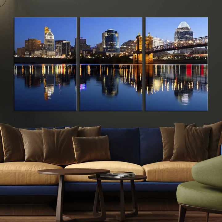 The Cincinnati City Lights Night Skyline Cityscape View Wall Art Canvas Print showcases a cityscape at night reflecting on water. It is crafted on museum-quality canvases with a UV-protective coating.