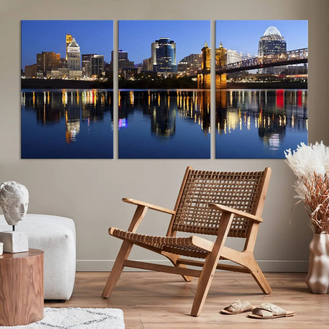 The Cincinnati City Lights Night Skyline Cityscape View Wall Art Canvas Print showcases a cityscape at night reflecting on water. It is crafted on museum-quality canvases with a UV-protective coating.