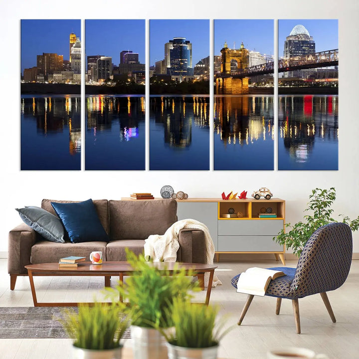 The Cincinnati City Lights Night Skyline Cityscape View Wall Art Canvas Print showcases a cityscape at night reflecting on water. It is crafted on museum-quality canvases with a UV-protective coating.