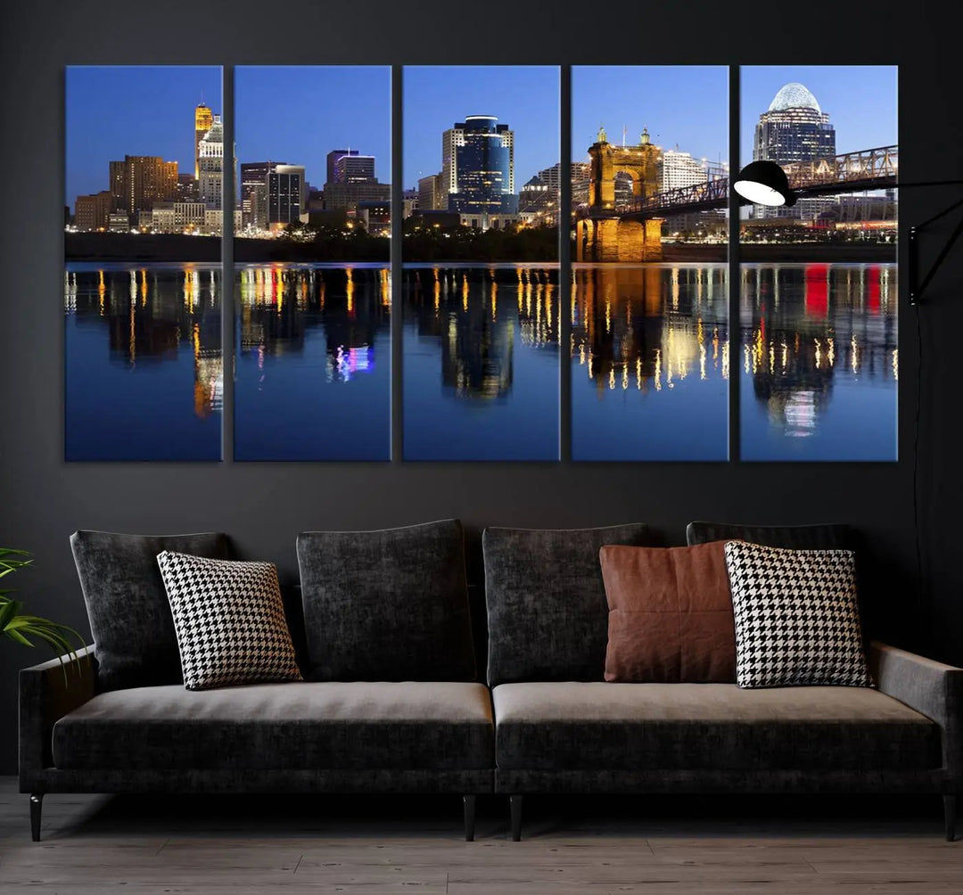 The Cincinnati City Lights Night Skyline Cityscape View Wall Art Canvas Print showcases a cityscape at night reflecting on water. It is crafted on museum-quality canvases with a UV-protective coating.