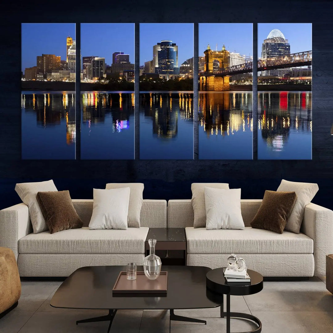 The Cincinnati City Lights Night Skyline Cityscape View Wall Art Canvas Print showcases a cityscape at night reflecting on water. It is crafted on museum-quality canvases with a UV-protective coating.