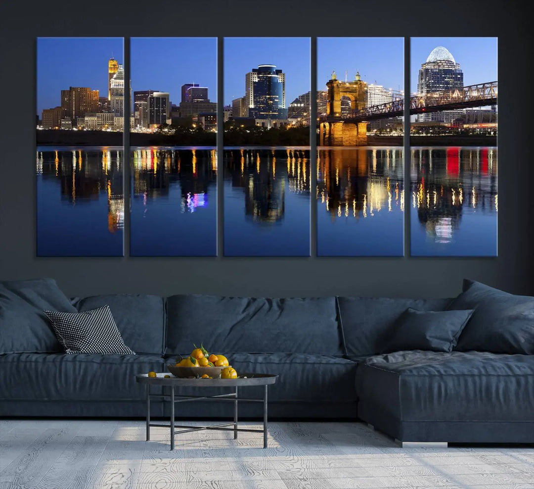 The Cincinnati City Lights Night Skyline Cityscape View Wall Art Canvas Print showcases a cityscape at night reflecting on water. It is crafted on museum-quality canvases with a UV-protective coating.