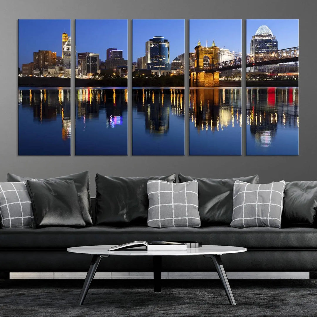 The Cincinnati City Lights Night Skyline Cityscape View Wall Art Canvas Print showcases a cityscape at night reflecting on water. It is crafted on museum-quality canvases with a UV-protective coating.