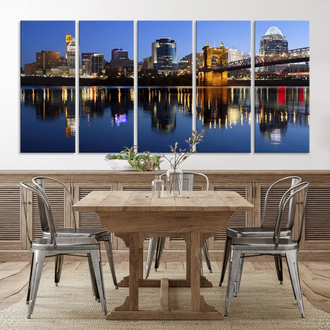 The Cincinnati City Lights Night Skyline Cityscape View Wall Art Canvas Print showcases a cityscape at night reflecting on water. It is crafted on museum-quality canvases with a UV-protective coating.