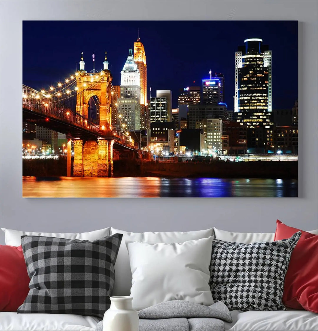 The Cincinnati City Lights Night Skyline Cityscape View Wall Art Canvas Print showcases a stunning night view of a city skyline with an illuminated bridge, making it an ideal museum-quality addition.