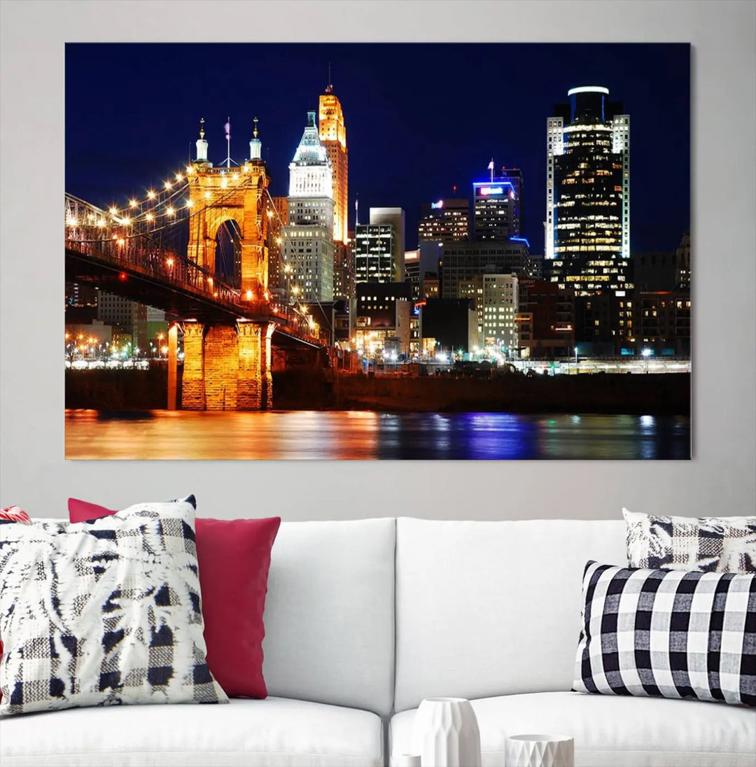 The Cincinnati City Lights Night Skyline Cityscape View Wall Art Canvas Print showcases a stunning night view of a city skyline with an illuminated bridge, making it an ideal museum-quality addition.