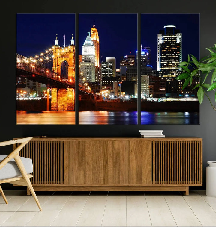 The Cincinnati City Lights Night Skyline Cityscape View Wall Art Canvas Print showcases a stunning night view of a city skyline with an illuminated bridge, making it an ideal museum-quality addition.