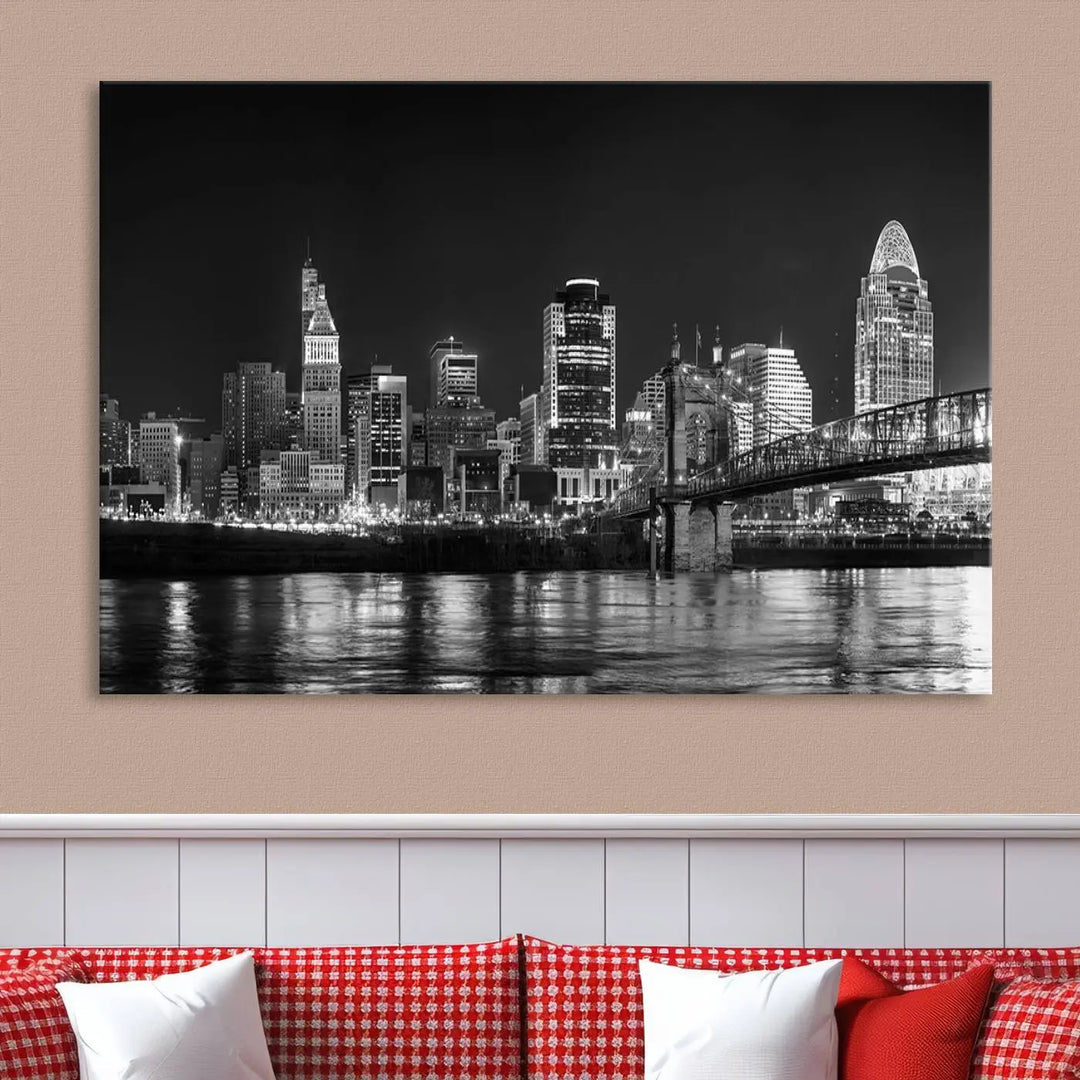 The Cincinnati City Lights Skyline Black and White Wall Art Cityscape Canvas Print elegantly adorns a modern living room. This museum-quality canvas triptych of a city skyline is enhanced by hand-assembled frames for added finesse, and you can enjoy free shipping on this stunning home addition.