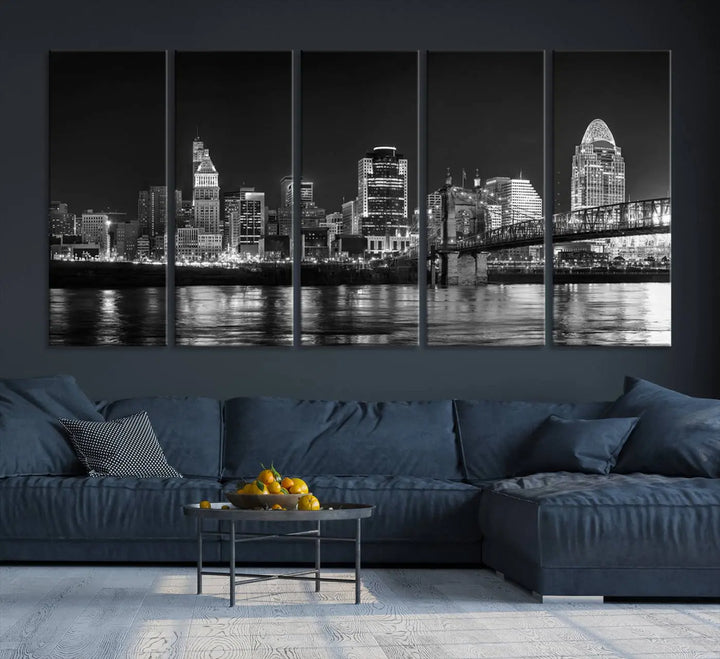 The Cincinnati City Lights Skyline Black and White Wall Art Cityscape Canvas Print elegantly adorns a modern living room. This museum-quality canvas triptych of a city skyline is enhanced by hand-assembled frames for added finesse, and you can enjoy free shipping on this stunning home addition.