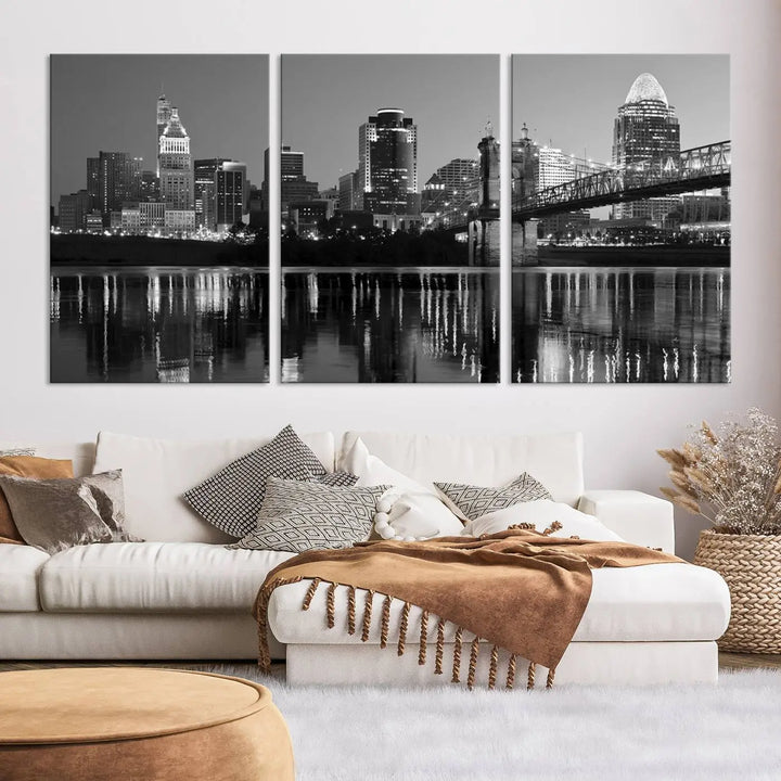 The wall showcases a ready-to-hang triptych of the Cincinnati City Lights Skyline in black and white, printed on museum-quality canvas.