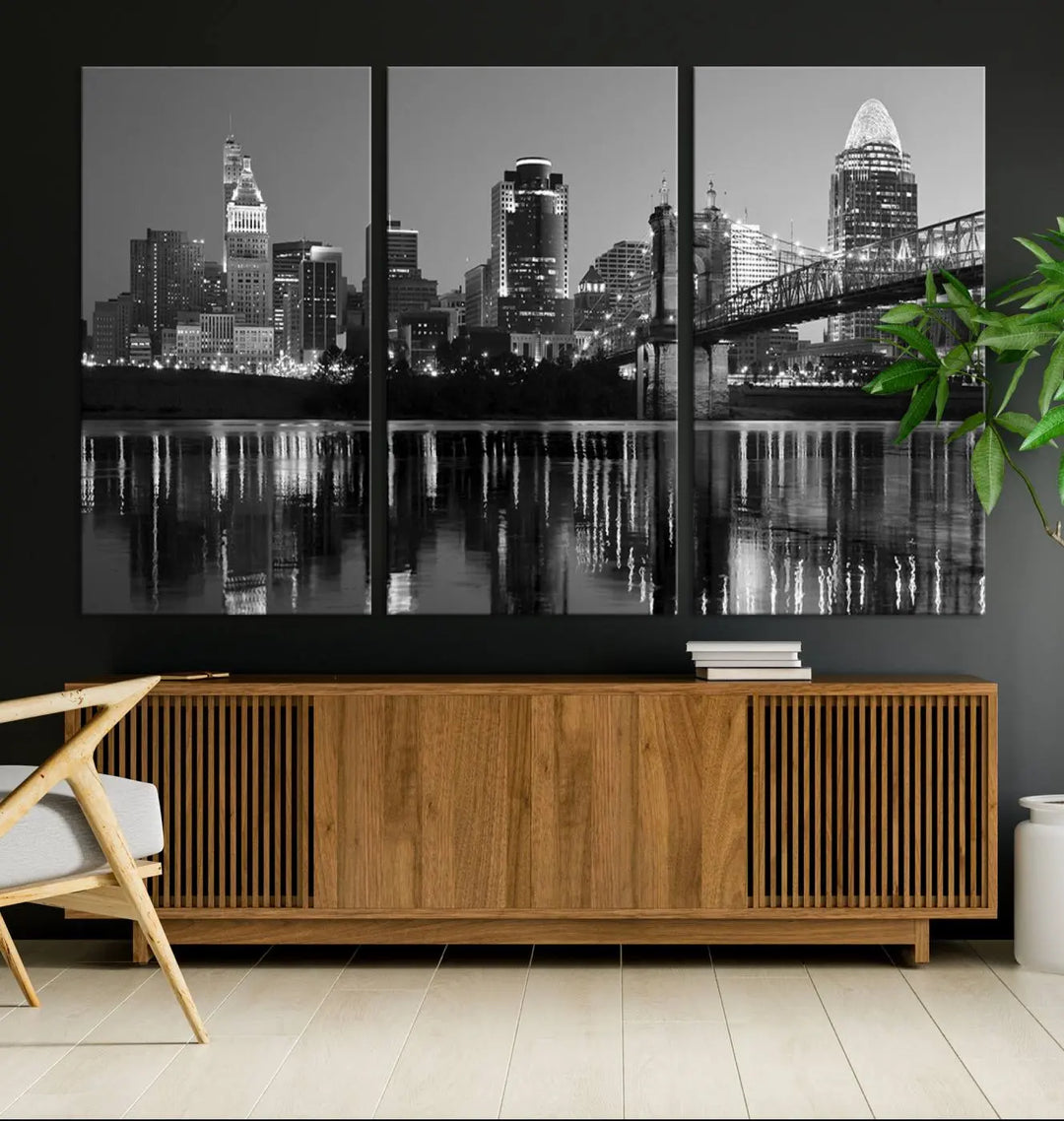 The wall showcases a ready-to-hang triptych of the Cincinnati City Lights Skyline in black and white, printed on museum-quality canvas.